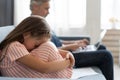 No Time For Child. Grey-haired dad busy with laptop, working online at home, sad bored offended daughter sitting near by Royalty Free Stock Photo