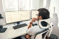 No time to relax. Back view of professional trader working with graph and financial reports on computer screens while