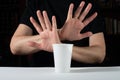 No to disposable plastic. Hand gesture rejects single-use plastic cup