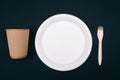 No to plastic. Wooden eco-friendly paper plate, cup and fork on dark background, top view. Time to change. New rules to