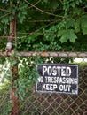 Grungy No Trespassing Sign on Rusty Chain Link Fence. Royalty Free Stock Photo