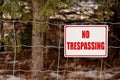 No Trespassing Sign Posted on a Wire Fence in a Rural Setting