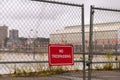 No trespassing sing hanged on an wire fence in front of a dockyard. Royalty Free Stock Photo