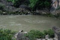 No water flows through the bridge, but the river is downstream.