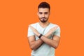 No way, absolutely not. Portrait of determined brunette man showing x sign with crossed hands. isolated on orange background Royalty Free Stock Photo