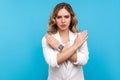 No way, never again. Portrait of determined serious woman crossing hands on chest, gesturing x sign. blue background