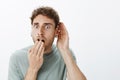 No way, tell me everything. Portrait of shocked and amazed handsome guy with fair hair, dropping jaw, covering opened