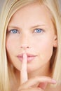 No words needed. Portrait of a young woman holding her finger in front of her lips. Royalty Free Stock Photo