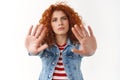 No you must stop. Serious-looking displeased ginger girl 25s curly hairstyle extend palms forward frowning prohibiting