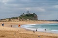 Nobbys lighthouse in distance on its hill at ocean in Newcastle, Australia