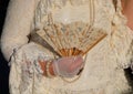 noblewoman with luxurious ivory white historical dress and a fan in gloved hand during masquerade Carnival in Venice Italy