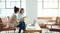 Nobodys opinion she values more than her colleague. two young businesswomen discussing paperwork in a modern office.