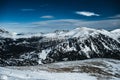 Nocky mountains in Alps photographed from a slope in February. Mountains full of trees partly covered in snow. Royalty Free Stock Photo