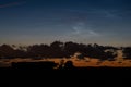 Noctilucent clouds above dark low level clouds