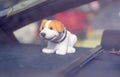 A nodding toy dog on the dashboard of a car on a window background Royalty Free Stock Photo