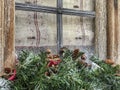 Noel decoration with pine tree branches in front of a window