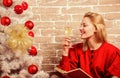 Noel and joy. Girl in red dress relaxing with glass of champagne near christmas tree. Woman happy drink alcohol near Royalty Free Stock Photo