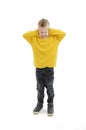 Noise, stress and people concept - Full length of stressed boy in yellow sweater closing ears by hands