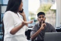 A noisy coworker can derail your productivity. a young businessman gesturing for his colleague to be quiet in an office. Royalty Free Stock Photo