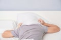 Noisy neighbors doing repairs interfere with sleep. Heavy morning awakening of man after sleep. Royalty Free Stock Photo