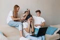 Noisy spoiled children prevent their mother from working remotely on a laptop while sitting at home on the couch. distract mom by Royalty Free Stock Photo