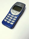 The iconic blue Nokia 3310, isolated on a beige background Royalty Free Stock Photo