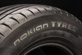 Nokian tyres , the logo of the Finnish tire company in close-up on the sidewall of the summer tire. dark background, Royalty Free Stock Photo