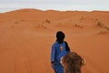 Nomad Berber pulling dromedary through Sahara