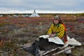 Housewife of nomad tribe takes a rest in front of camp during reindeer migration.