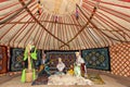 Nomadic people in traditional clothes in a yurt, Almaty, Kazakhstan.