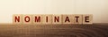 Nominate word on wooden cubes. Concept of words to put forward a candidat for voting or election