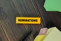 Nominations write on sticky note isolated on Wooden Table