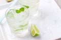 Non alcohol cold mojito cocktail with fresh lime, mint and crushed ice on a white plate on a vintage wooden background Royalty Free Stock Photo