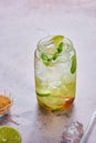 Non-alcoholic soft drink with lime slices, ice cubes and fresh mint in a jar-shaped glass on a brown background Royalty Free Stock Photo