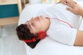 Non binary man listening to music relaxed on bed at bedroom