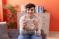 Non binary man smiling confident playing video game at home Royalty Free Stock Photo