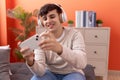 Non binary man smiling confident playing video game at home Royalty Free Stock Photo