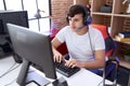 Non binary man streamer playing video game using computer at gaming room Royalty Free Stock Photo