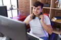 Non binary man streamer smiling confident sitting on table at gaming room