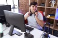 Non binary man streamer smiling confident sitting on table at gaming room