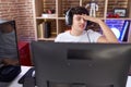 Non binary man streamer stressed using computer at gaming room