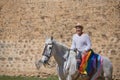 Non-binary person, young and South American, very makeup, mounted on a white horse, smiling and happy, with a gay pride flag on Royalty Free Stock Photo