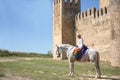 Non-binary person, young and South American, very makeup, mounted on a white horse, smiling and happy, with a gay pride flag on Royalty Free Stock Photo