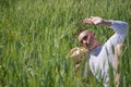 Non-binary person, young and South American, very makeup, posing lying in the middle of a field of green wheat. Concept queen, Royalty Free Stock Photo