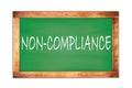 NON-COMPLIANCE text written on green school board