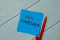 Non Compliance write on sticky notes isolated on Wooden Table Royalty Free Stock Photo