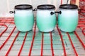 Non-freezing coolant based on propylene glycol in plastic drums. Underfloor heating from red pipes Royalty Free Stock Photo