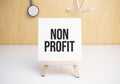 Non Profit sign on small wood board rest on the easel with medical stethoscope
