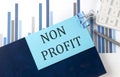 NON PROFIT on sticky note on the notebook on the chart background Royalty Free Stock Photo