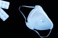 White ffp3 face mask with a valve and painkillers on a black background Royalty Free Stock Photo